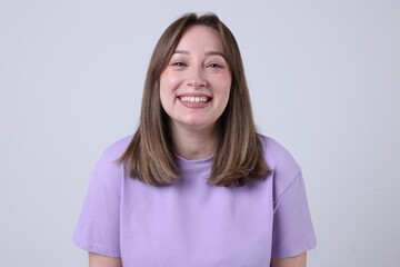 Attractive woman laughing on grey background. Positive emotion