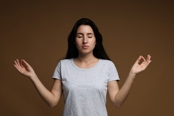 Panic attack. Woman meditating to calm down on brown background