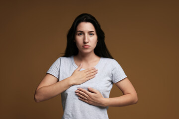 Obraz premium Panic attack. Woman breathing to calm down on brown background