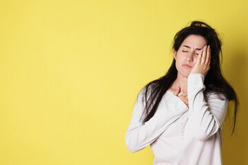 Woman suffering from hangover on yellow background, space for text