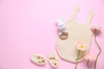 Baby clothes, flowers and accessory on pink background, flat lay. Space for text