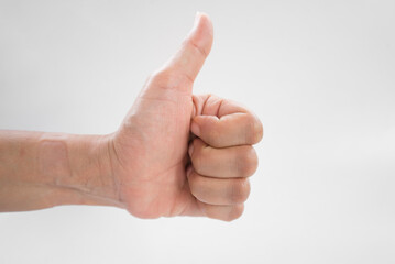 Hand showing thumbs up sign isolated on white background, selective focus.