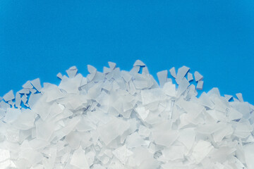 White crystals sea salt flakes. Top view on blue background.
