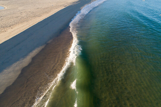 Aerial drone view of a wide white sand beach and dunes, a pristine paradise beach