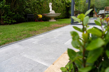 Terrasse extérieure avec carrelage imitation béton gris clair, design moderne et minimaliste
