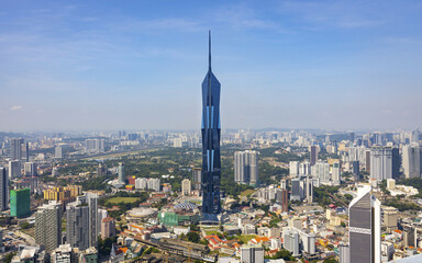 View of modern skyscraper Merdeka 118 piercing the clear blue sky, standing tall amidst a sprawling cityscape with vibrant green spaces, Kuala Lumpur, Federal Territory of Kuala Lumpur.