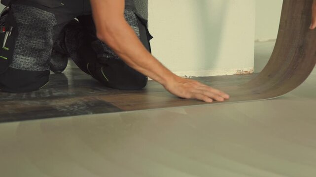 Construction worker installing vinyl laminate flooring