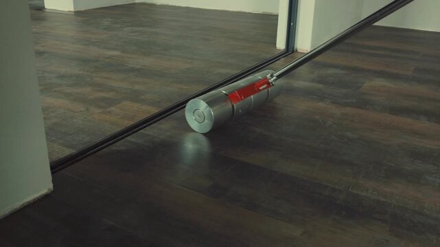 Worker using heavy roller to install vinyl laminate flooring