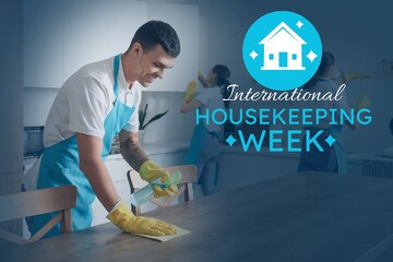 Male janitor cleaning table in kitchen. Happy International Housekeeping Week