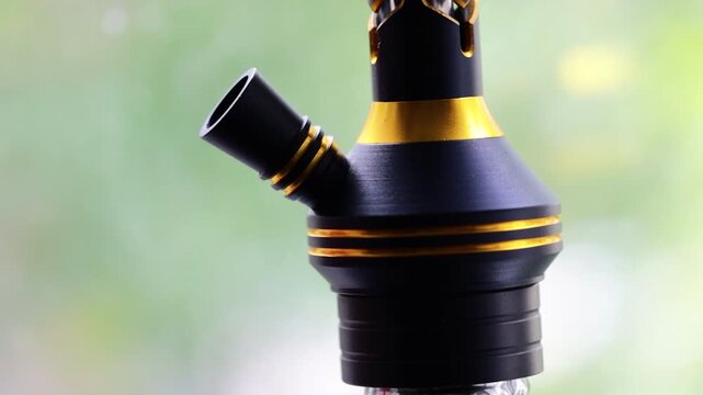 Hoad hook is close -up against the background of nature. Tobacco smoking device