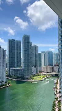 TIMELAPSE - Brickell Key landscape in Miami, Florida, presents a stunning view of iconic skyscrapers and the Miami River, glistening under a clear sky, creating a vibrant urban landscape, USA