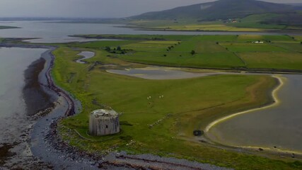 Smooth dynamic aerial of Aughinish Martello Tower, featuring the island, causeway, inlet, and surrounding County Clare landscape.
