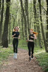 Fototapeta premium Women jogging on a forest trail for fitness