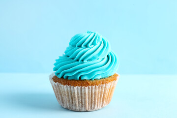 Tasty cupcake on blue background