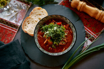 A Flavorful Bowl of Rich, Hearty Stew Garnished with Fresh Herbs, Served with Slices of Bread on a Decorative Table Setting