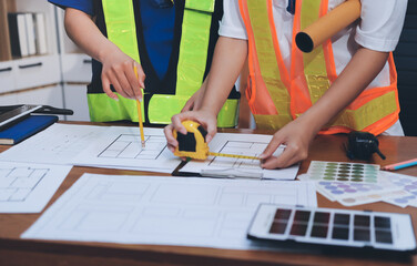 Closeup of team of industrial engineers meeting analyze machinery blueprints consult project on...