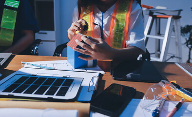 Closeup of team of industrial engineers meeting analyze machinery blueprints consult project on...