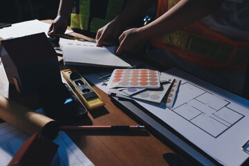 Closeup of team of industrial engineers meeting analyze machinery blueprints consult project on...