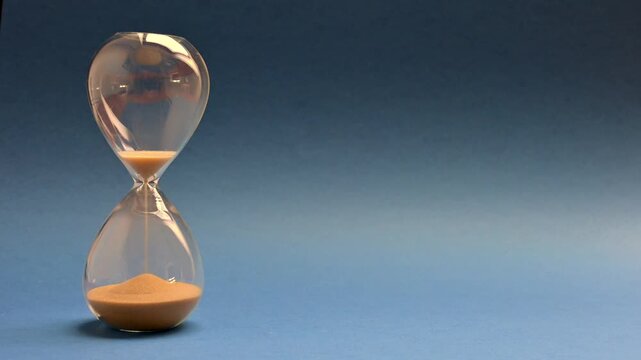 Concept Turn back Time . Sand moving backwards in an hourglass. 	