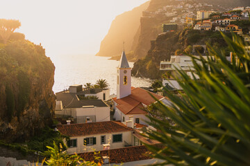 Picturesque fishing village of Camara de Lobos, Madeira, with colorful boats, coastal cliffs, and...