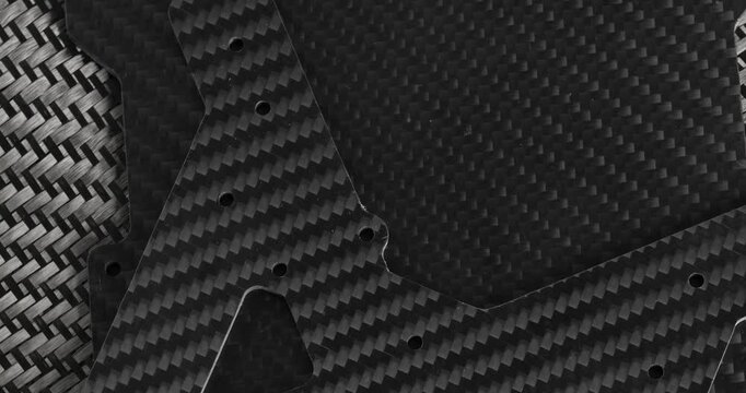 Carbon fabric and carbon parts in close-up on a rotating table. Raw materials for carbon production.