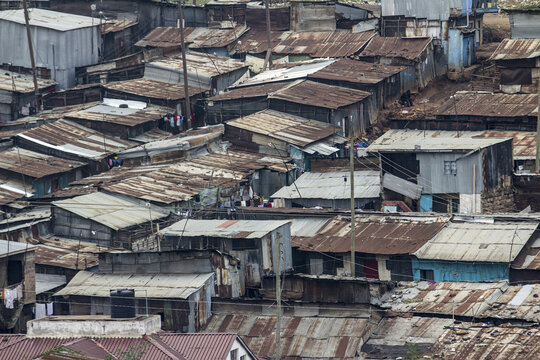 View of corrugated iron roofs of closely packed houses create a textured landscape under a cloudy sky, a stark reminder of urban poverty, Nairobi, Nairobi County, Kenya.