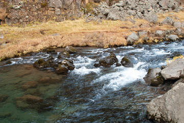A breathtaking view of a majestic waterfall cascading over rugged rocks in the Crimean mountains,...
