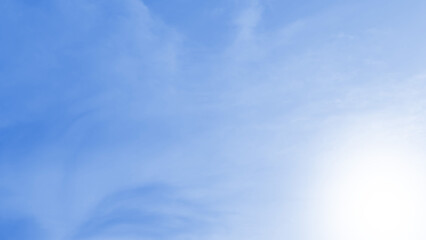 A soft, blurred light blue background featuring subtle cloud-like textures and a bright, gentle white sunlight glow.