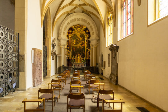View of rows of chairs leading to an ornate golden altar beneath vaulted ceilings in the Stadtpfarrkirche, Graz, Styria, Austria.