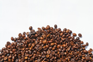 Heap roasted coffee beans. Top view on white background. Space for text.