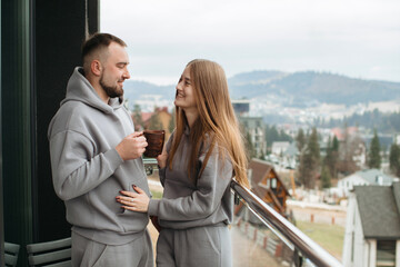 Young couple sharing a moment on balcony with mountain view