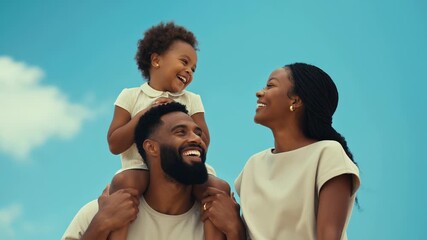 Smiling father carrying daughter on shoulders next to his wife, enjoying a sunny day with blue sky and some clouds, creating a heartwarming scene of family bonding