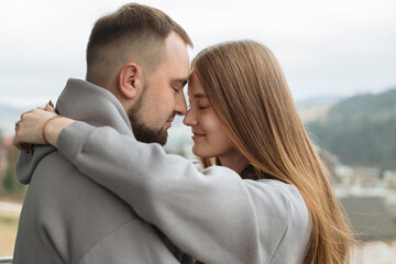 Young couple embracing and touching noses on balcony