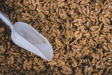 Muchas nueces peladas en venta. Pala para coger las nueces. Fruto seco en forma de cerebro. 