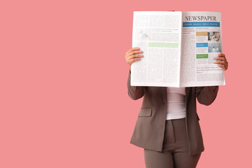 Young African-American woman with newspaper on pink background