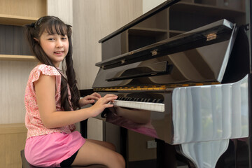 young talent girl practicing electone instrument in house