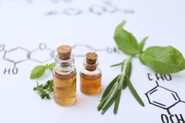 Different herbs and bottles of cosmetic products on paper with chemical formulas, closeup