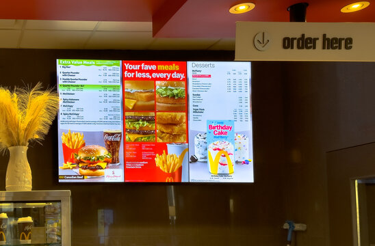 Calgary, Alberta, Canada. Aug 3, 2025. A digital menu board at McDonald's displays diverse food and dessert options, showcasing modern fast-food ordering and tempting culinary choices.