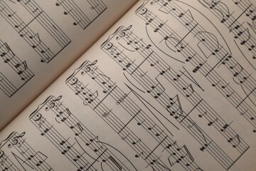 Sheets with musical notes as background, top view