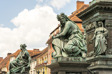 View of weathered bronze statues stand guard against a backdrop of terracotta rooftops and a bright sky, capturing the essence of history, Graz, Graz, Austria.