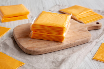Stack of American Cheese Slices in Wrappers, side view.