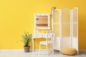 Interior of dressing room with makeup table and folding screen