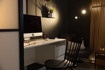 Stylish workplace with desk, computer and stationery at home office. Interior design