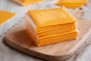 Stack of American Cheese Slices in Wrappers, side view.