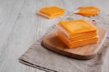 Stack of American Cheese Slices in Wrappers, side view.