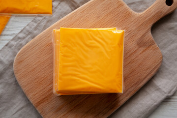Stack of American Cheese Slices in Wrappers, top view. Flat lay, overhead.