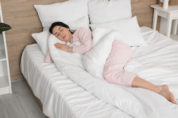 Pretty young woman sleeping in bed at home