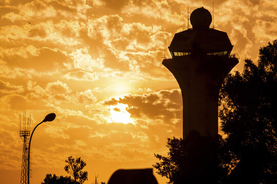 Nairobi, Kenya - 26 August 2014: View of the control tower silhouetted against a fiery sunset, with golden clouds painting the sky above Embakasi.