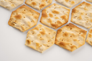 Whole grain crackers with spices and herbs isolated on white background. Dry salted cookies with crackers. Stack of various crispy wheat, rye and corn tortillas with sesame and sunflower seeds
