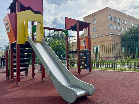 A playground next to a multi-storey residential building in Russia. High quality photo